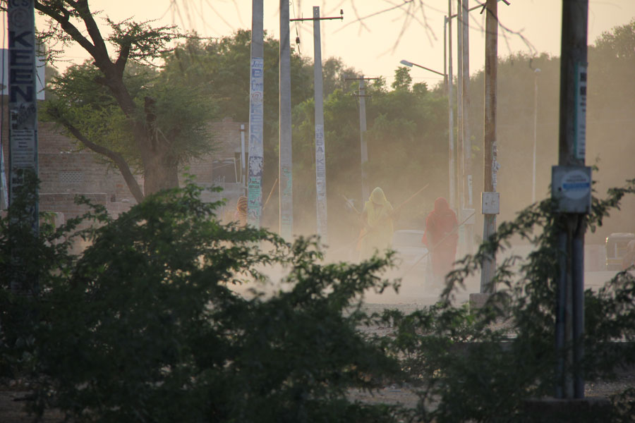 Des femmes de la caste des intouchables balaient un bord de rue dans le soleil couchant. Bikaner, Rajasthan